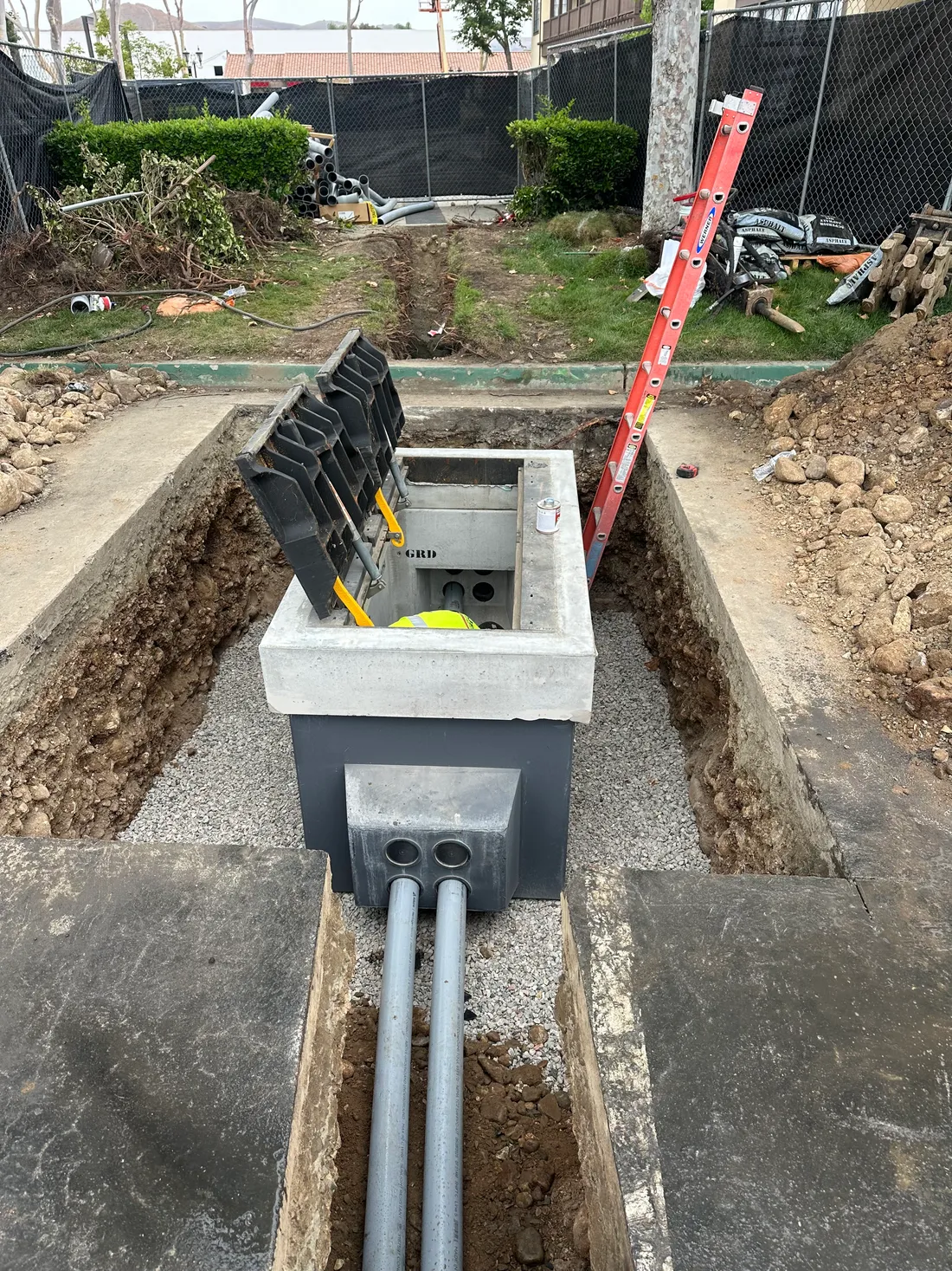 Precast electrical vault set in an open trench with conduit runs entering