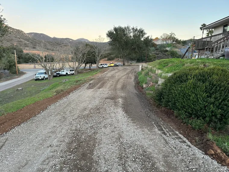 New gravel access road graded through a residential property